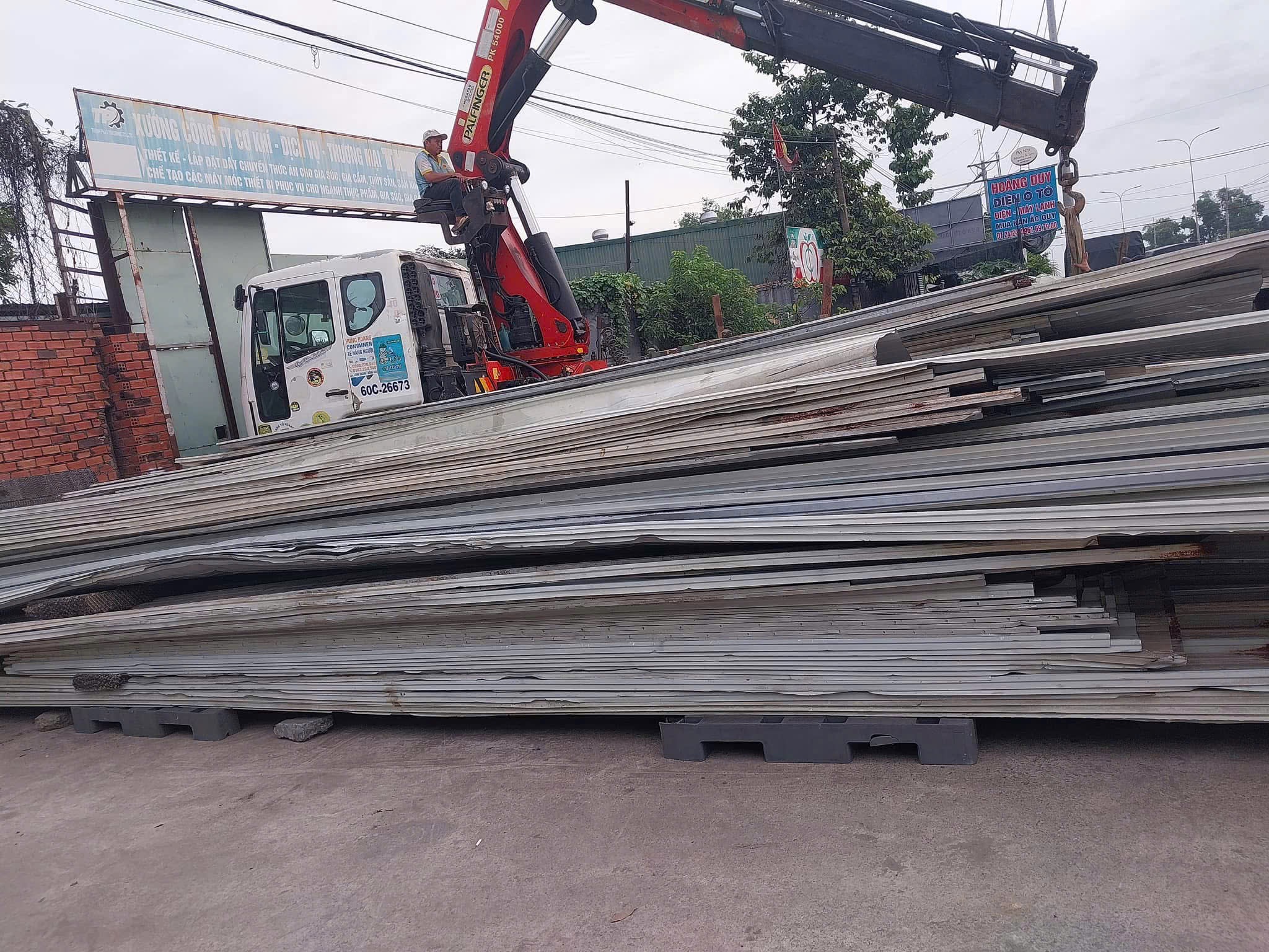 công nhân đang tháo dỡ tôn cũ trên mái nhà xưởng
